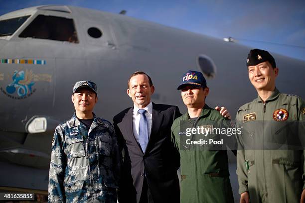 Australian Prime Minister Tony Abbott poses in front of a Royal Australian Air Force AP-3C Orion aircraft with the leaders of China's, Japan's and...