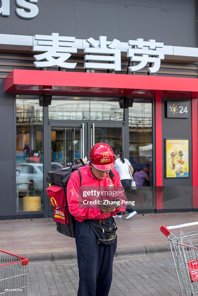 A take-out deliveryman is checking message on his mobile...