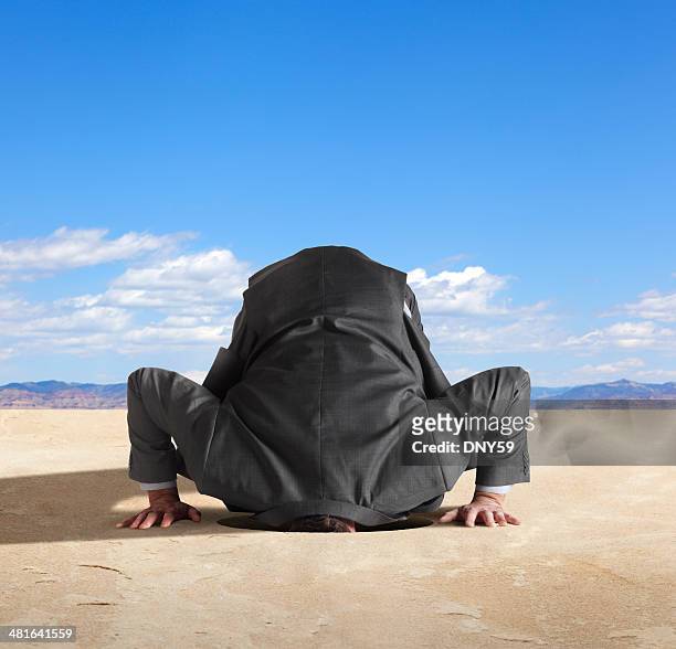 uomo d'affari con la testa nella sabbia - nascondere la testa nella sabbia foto e immagini stock