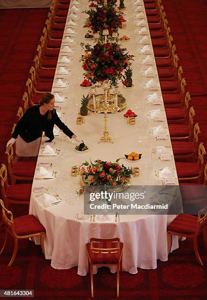 Table settings are laid out in the Palace Ballroom for a State Banquet at The Royal Welcome Summer opening exhibition at Buckingham Palace on July...