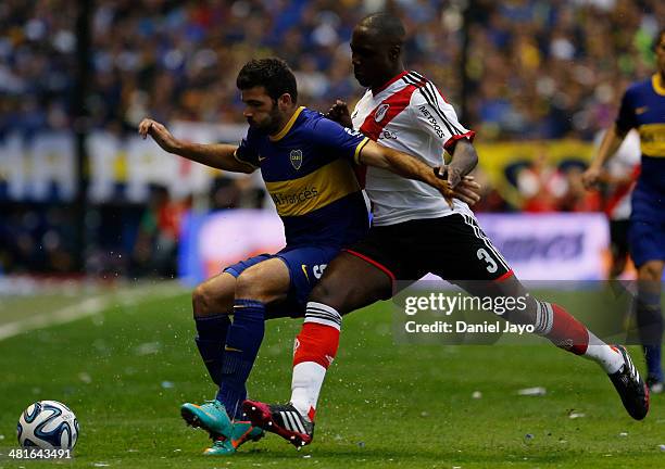 Emanuel Gigliotti, of Boca Juniors, and Eder Alvarez Balanta, of River Plate, fight for the ball during a match between Boca Juniors and River Plate...