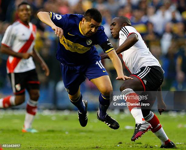 Juan Roman Riquelme, of Boca Juniors, falls down after allegedly being tackled by Eder Alvarez Balanta , of River Plate, during a match between Boca...