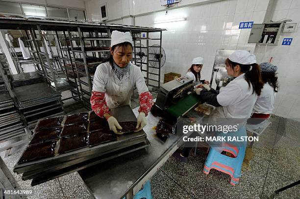 China-food-culture-lifestyle,FEATURE by Carol Huang This photo taken on February 22, 2014 shows workers preparing hot pot sauce made of fermented...