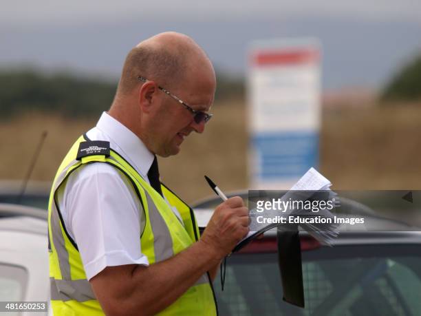 Civil Enforcement Office / Traffic warden giving a parking ticket, Devon, UK.