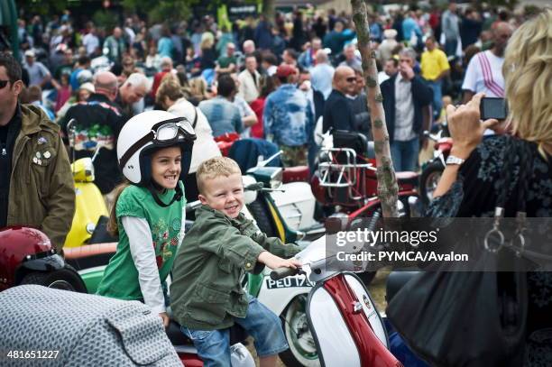 Children pose for a photograph on a Scooter at the Isle Of Wight Scooter Rally 2009..