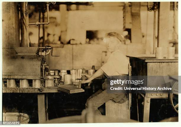 Boy working at an American canning machine with open gearing. 1909 Baltimore, Maryland. Published: 1909 July 7.