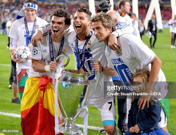 Pepe, Cristiano Ronaldo and Fabio Coentrao of Real Madrid celebrate with the trophy following their team's victory during the UEFA Champions League...