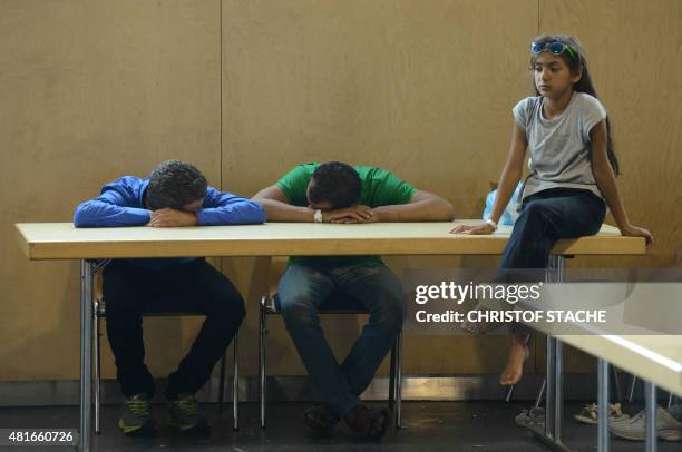Refugees wait to be processed in the first registration point of the German federation police in Passau, southern Germany, on July 23, 2015. Hundreds...