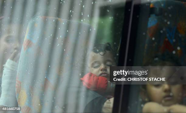 Refugees arrive in a bus at the first registration point of the German federation police in Passau, southern Germany, on July 23, 2015. Hundreds of...