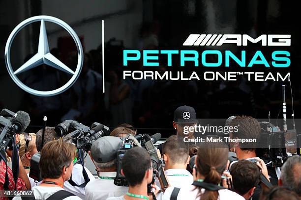 Lewis Hamilton of Great Britain and Mercedes GP speaks with members of the media in the paddock during previews to the Formula One Grand Prix of...