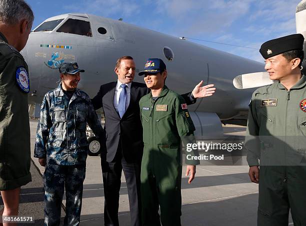 Australian Prime Minister Tony Abbott gathers for a picture in front of a Royal Australian Air Force AP-3C Orion aircraft with the leaders of...