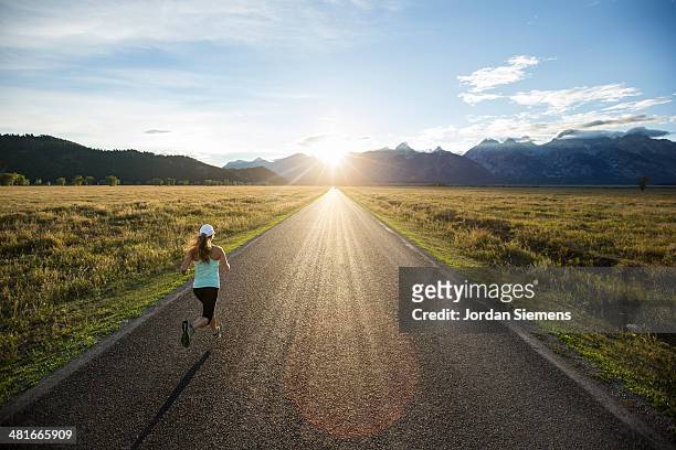 a female running at sunset. - capelli lunghi foto e immagini stock