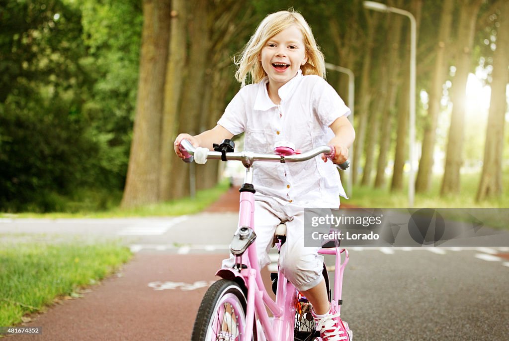 Young blonde girl riding her bike