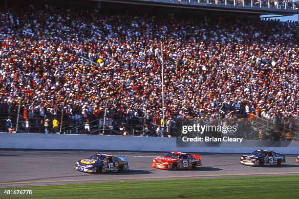 Dale Earnhardt races behind the cars of Michael Waltrip and Dale Earnhardt Jr as they race for the lead in the late stages of the Daytona 500, at...