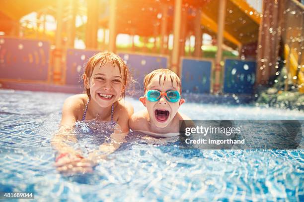 hermano y hermana divirtiéndose en el parque acuático - tobogán de agua fotografías e imágenes de stock