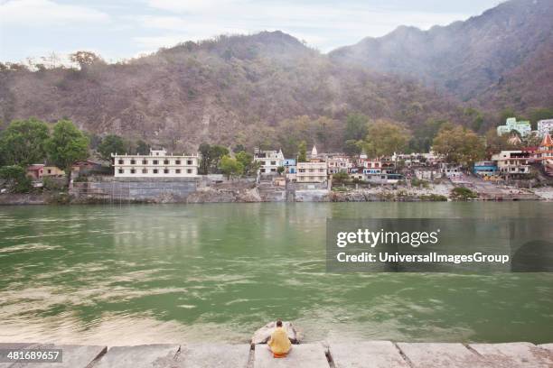 Man meditating at the riverside, River Ganges, Rishikesh, Dehradun District, Uttarakhand, India.