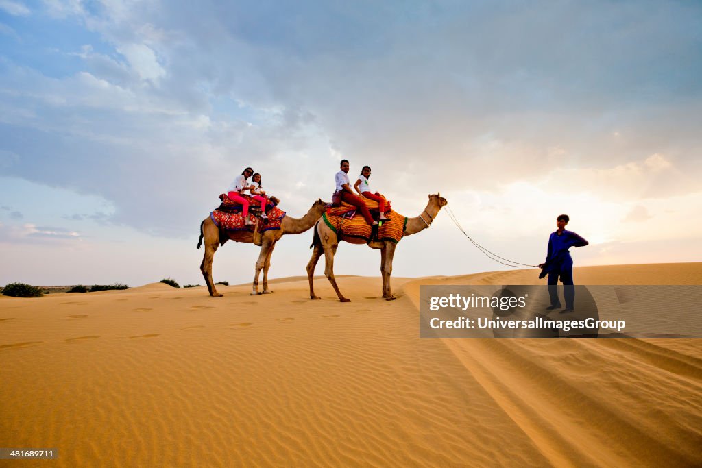 Tourists enjoying the camel safari in a desert, Thar Desert, Jaisalmer, Rajasthan, India