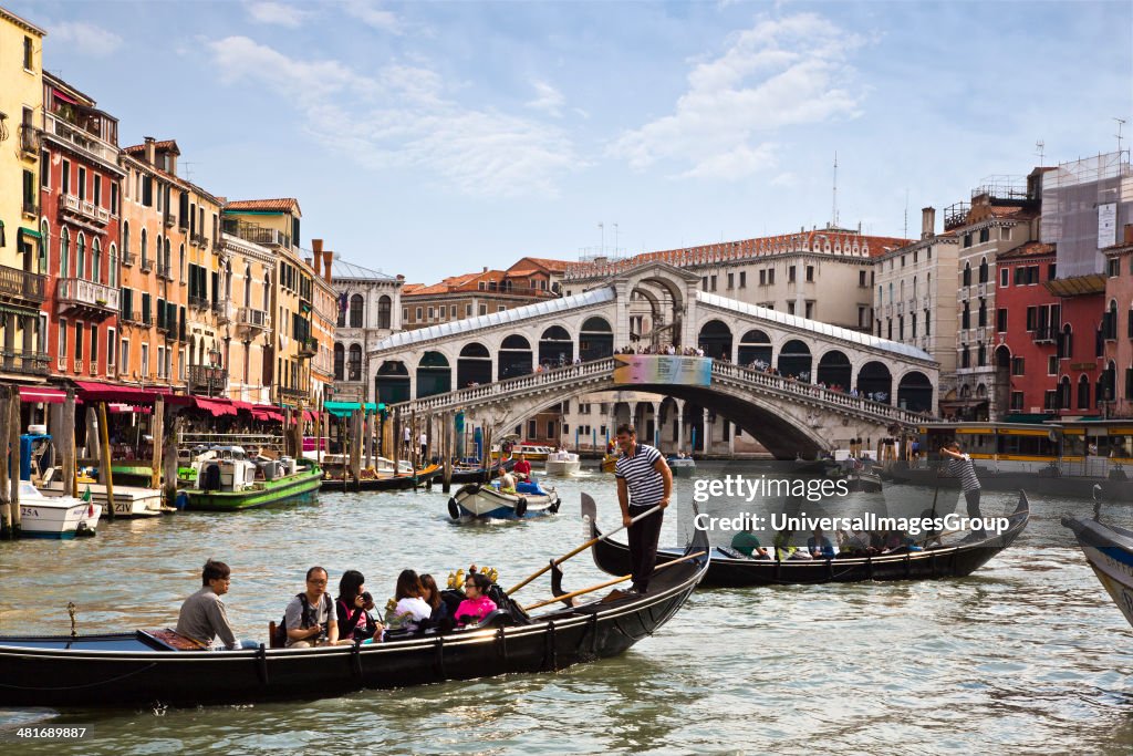 People travelling in gondolas with a Rialto Bridge in the background, Grand Canal, Venice, Veneto, Italy