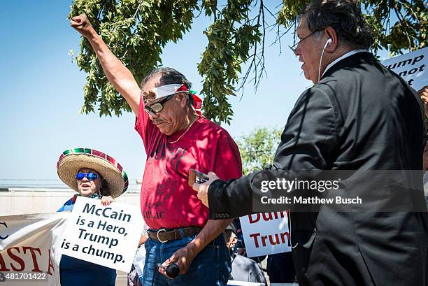 Protester raises his fist in front of the Laredo Airport as Republican Presidential candidate and business mogul Donald Trump visits during his trip...