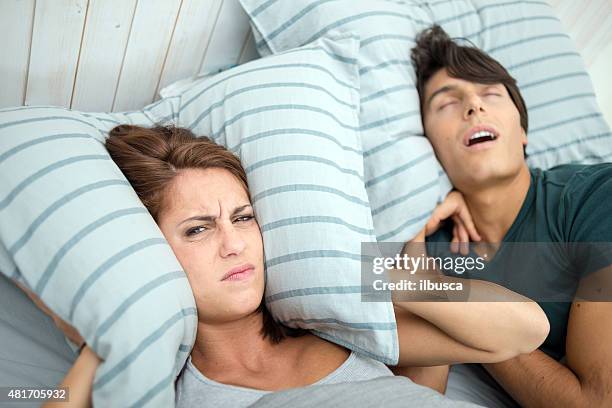 in bed: woman can't sleep - snoring husband stock pictures, royalty-free photos & images