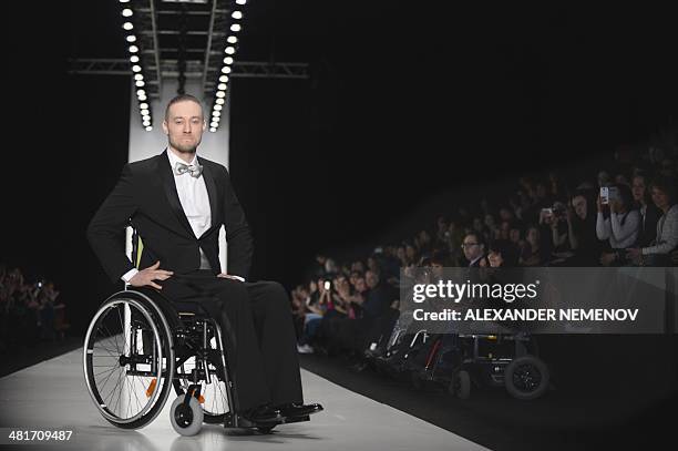 Disabled model presents a creation by designer Miguel Angelo Fernandes Carvalho during the "Fashion Without Borders" show of the Mercedes-Benz...