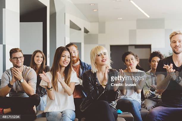 large group of students on seminar clapping hands - men and women in a large group listening stock pictures, royalty-free photos & images
