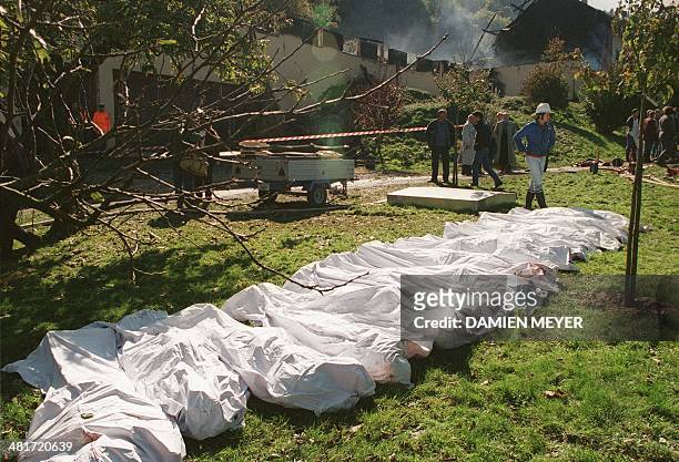 Police and firemen lay out the bodies of persons found at a farm 05 October 1994 in Cheiry, Fribourg county, Switzerland. On the 4th and the 5th of...