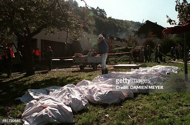 Police and firemen lay out the bodies of persons found at a farm on October 05, 1994 in Cheiry, Fribourg county, Switzerland. On the 4th and the 5th...