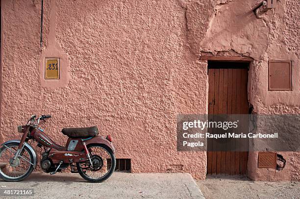 Mobylette motorbike parked at a house doorway.