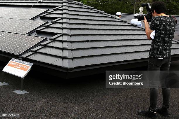 Photographer takes a photograph of Panasonic Corp. Solar panels integrated into a building roof design at the company's Eco Solutions solar module...