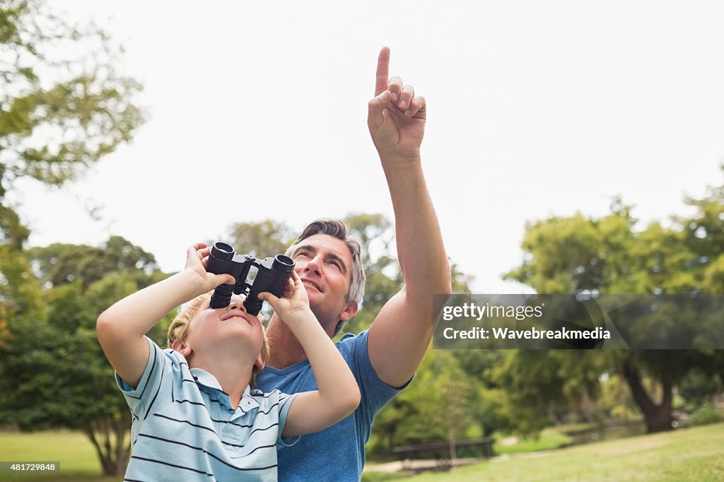 Father and his son using binocular in the park