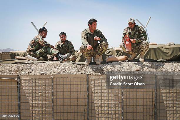 Afghan National Army soldiers eat lunch at an outpost along the Kabul-Gardez Highway on March 31, 2014 near Pul-e Alam, Afghanistan. Soldiers at the...