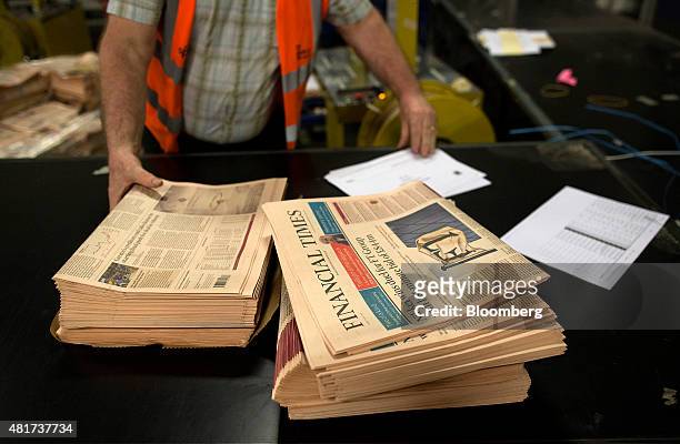 An employee sorts out copies of the Financial Times newspaper for delivery at a John Menzies Plc distribution center in London, U.K., on Friday, July...
