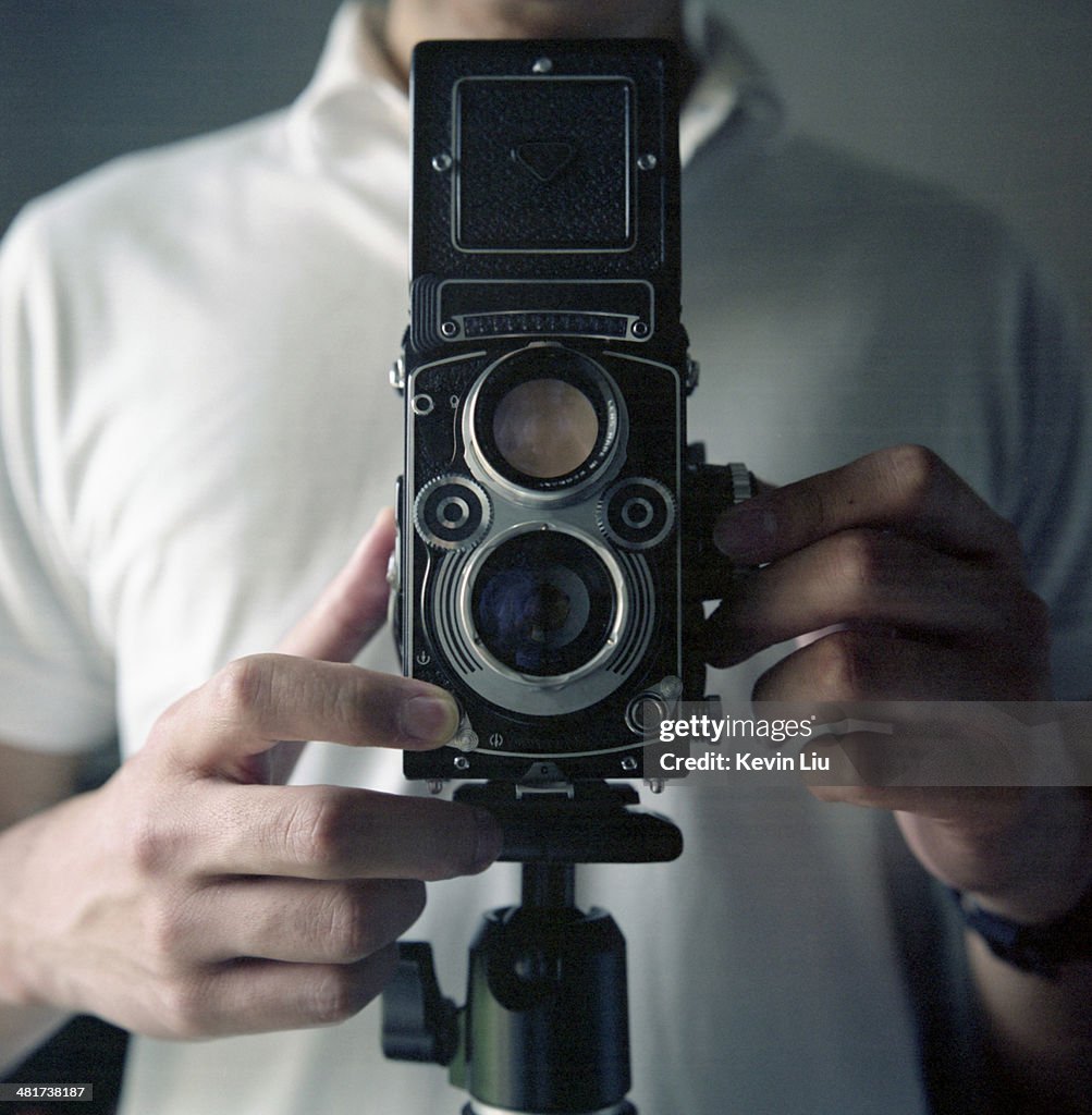 Man taking picture with a vintage camera on tripod