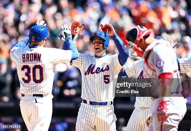 David Wright celebrates with teammate Andrew Brown of the New York Mets after Brown hit a three run homer in the first inning as Wilson Ramos of the...