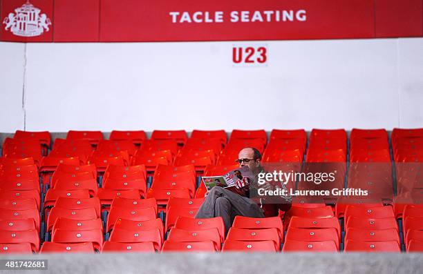 Sunderland fan reads his programme prior to kickoff during the Barclays Premier League match between Sunderland and West Ham United at the Stadium of...