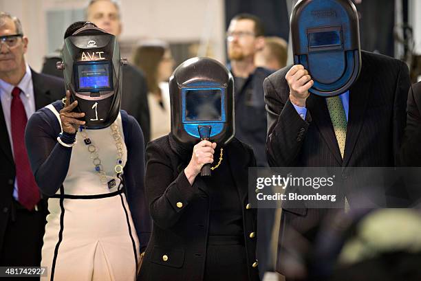 Janet Yellen, chair of the U.S. Federal Reserve, center, and Charles Plosser, chairman of the Federal Reserve Bank of Chicago, right, hold welding...