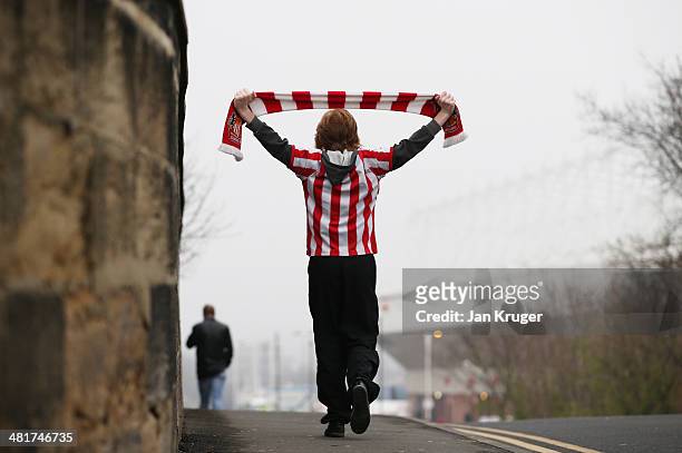 Sunderland fan makes his way to the stadium prior to kickoff during the Barclays Premier League match between Sunderland and West Ham United at the...
