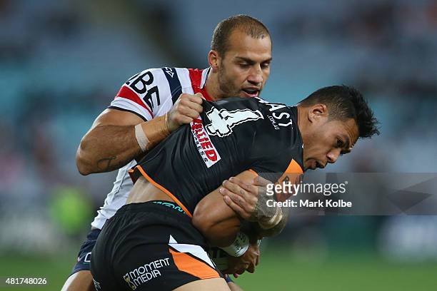 Blake Ferguson of the Roosters tackles Tim Simona of the Wests Tigers during the round 20 NRL match between the Wests Tigers and the Sydney Roosters...
