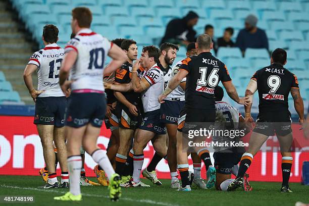 James Tedesco of the Wests Tigers celebrates with his team mates after scoring a try during the round 20 NRL match between the Wests Tigers and the...