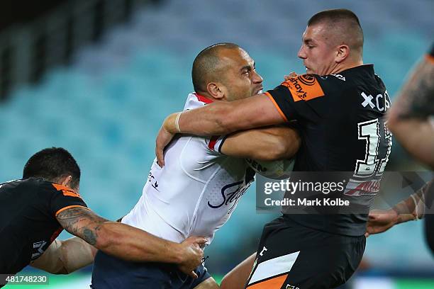 Sam Moa of the Roosters is tackled by Kyle Lovett of the Wests Tigers during the round 20 NRL match between the Wests Tigers and the Sydney Roosters...