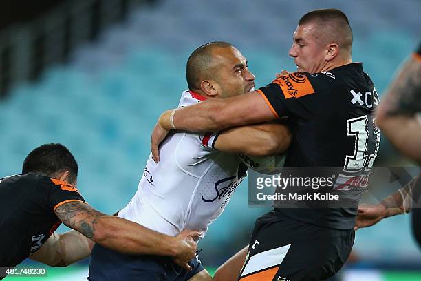 Sam Moa of the Roosters is tackled by Kyle Lovett of the Wests Tigers during the round 20 NRL match between the Wests Tigers and the Sydney Roosters...