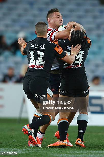 Jared Waerea-Hargreaves of the Roosters is tackled by Kyle Lovett and Martin Taupau of the Wests Tigers during the round 20 NRL match between the...