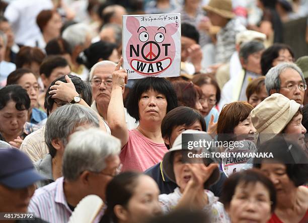 Woman holds a banner during an anti-government rally at a park beside the National Diet in Tokyo on July 24, 2015 to protest against the...