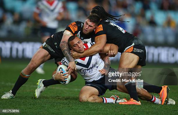 Sio Siua Taukeiaho of the Roosters is tackled during the round 20 NRL match between the Wests Tigers and the Sydney Roosters at ANZ Stadium on July...