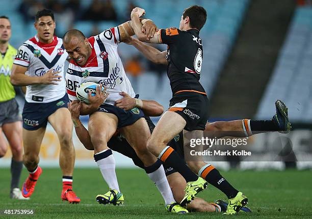 Sam Moa of the Roosters is tackled during the round 20 NRL match between the Wests Tigers and the Sydney Roosters at ANZ Stadium on July 24, 2015 in...