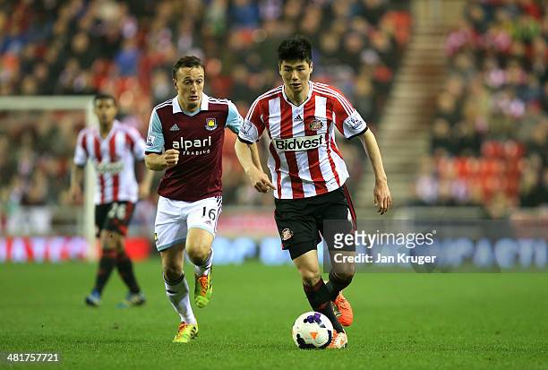 Ki Sung-Yong of Sunderland is pursued by Mark Noble of West Ham during the Barclays Premier League match between Sunderland and West Ham United at...