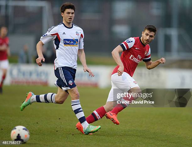 Jon Toral of Arsenal passes the ball under pressure from Andy Robinson of Bolton during the match between Bolton Wanderers U21 and Arsenal U21 in the...