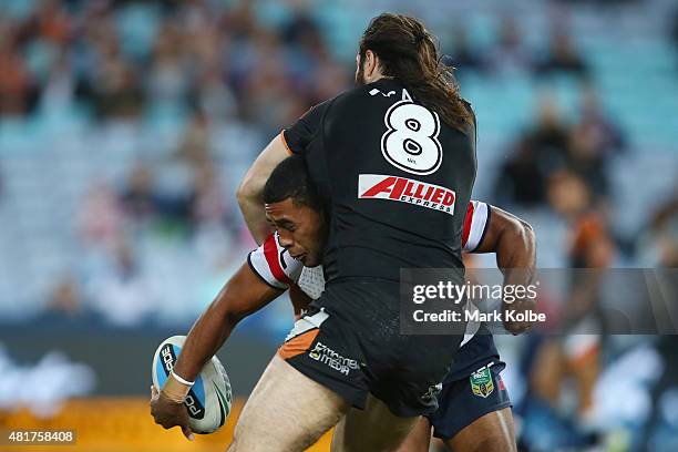 Michael Jennings of the Roosters throws a flick pass as he is tackled by Aaron Woods of the Wests Tigersduring the round 20 NRL match between the...