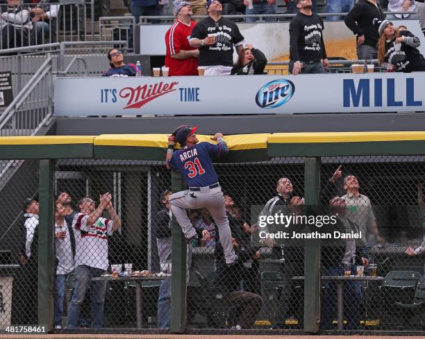 Oswaldo Arcia of the Minnesota Twins and fans watch as a home run ball hit by Alejandro De Aza of the Chicago White Sox sails out of the park during...